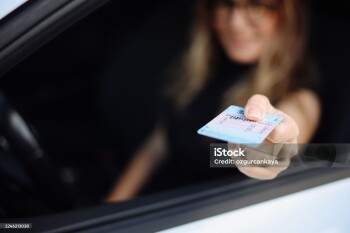 Young businesswoman shows her driver's license to authorities