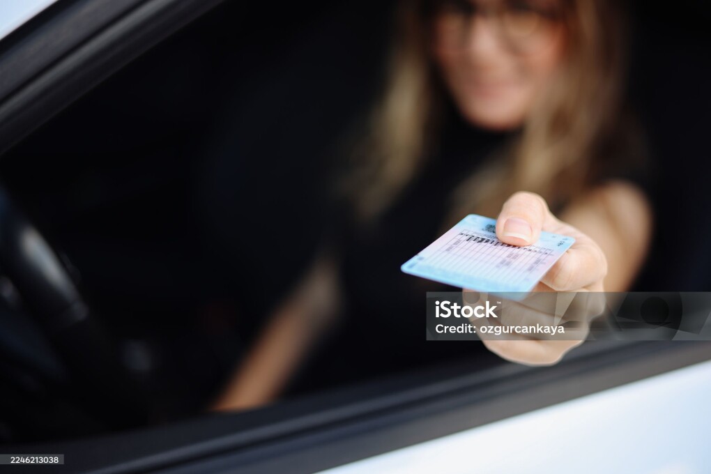 Young businesswoman shows her driver's license to authorities