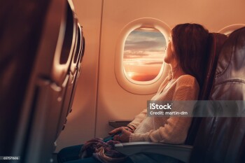 Woman in airplane looking through the window