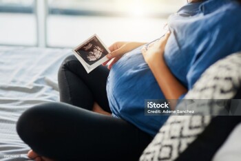 Closeup shot of an unrecognizable pregnant woman holding an ultrasound scan