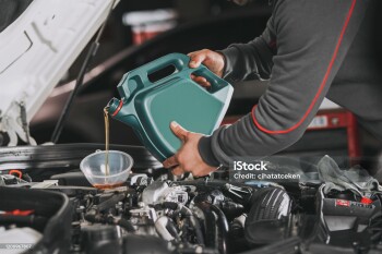 Pouring oil to car engine.