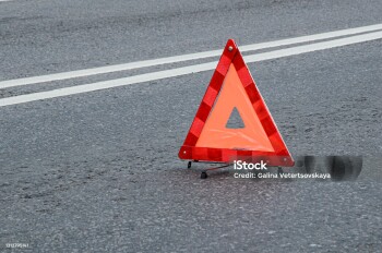 Red warning triangle on the carriageway with a double dividing strip. Traffic rules, traffic accidents, road safety.