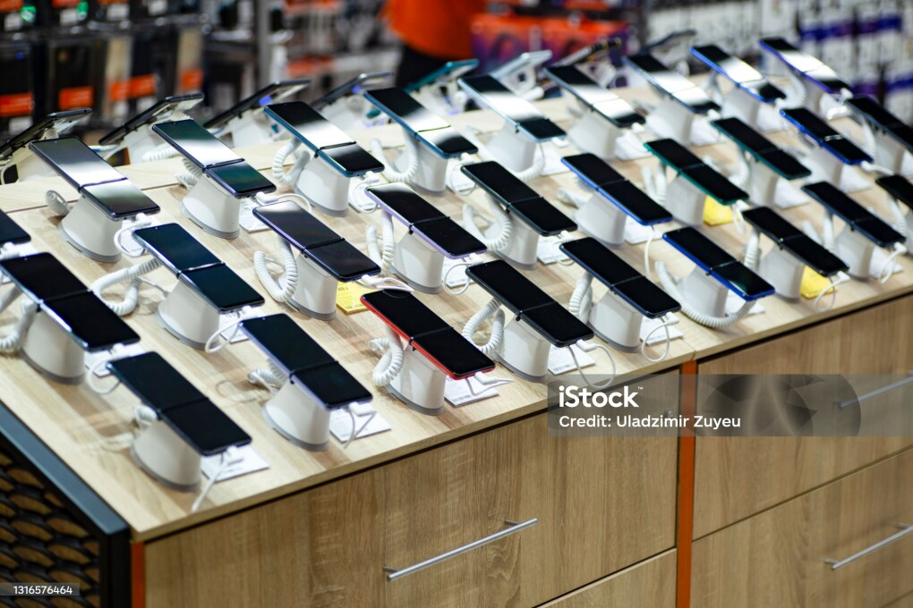 Smartphones store. Showcase with selling various new smartphones in electronics store during a sale. Mobile phone market concept. High quality photo