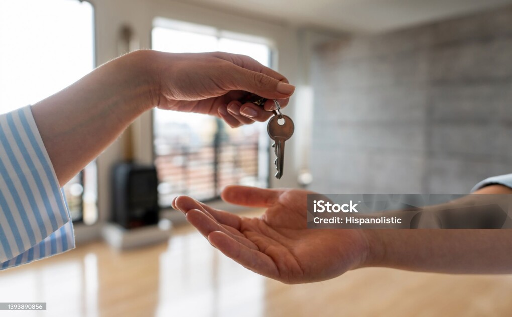 Close-up on a real estate agent giving the keys of his new house to a man - home ownership concepts