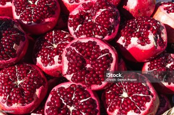 a lot of ripe red pomegranates with a cut off top, close-up background, space for an inscription. High quality photo