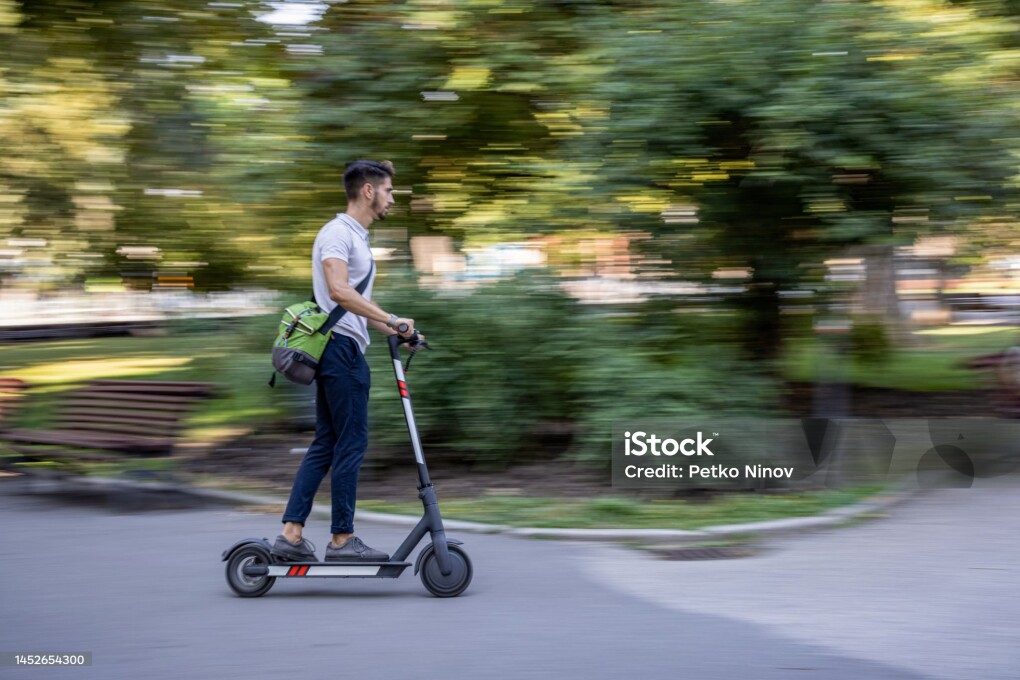 Motion blurred image of man with e-scooter