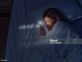 High angle view of a woman taking a nap in her bed at night. Photographed in medium format.