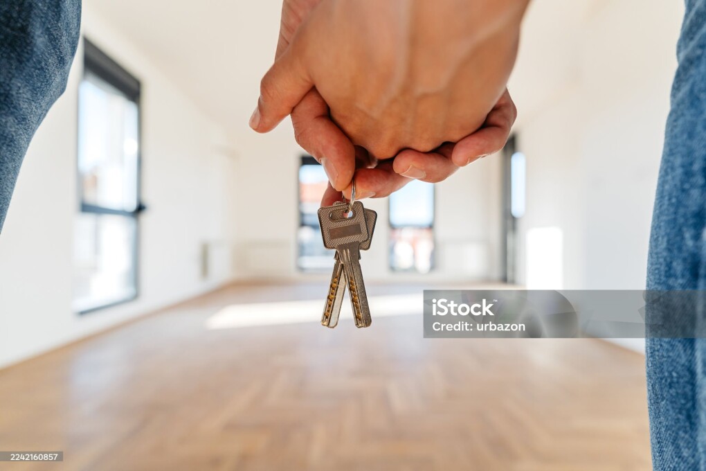 Young couple holding keys of an apartment they just bought. Close-up.