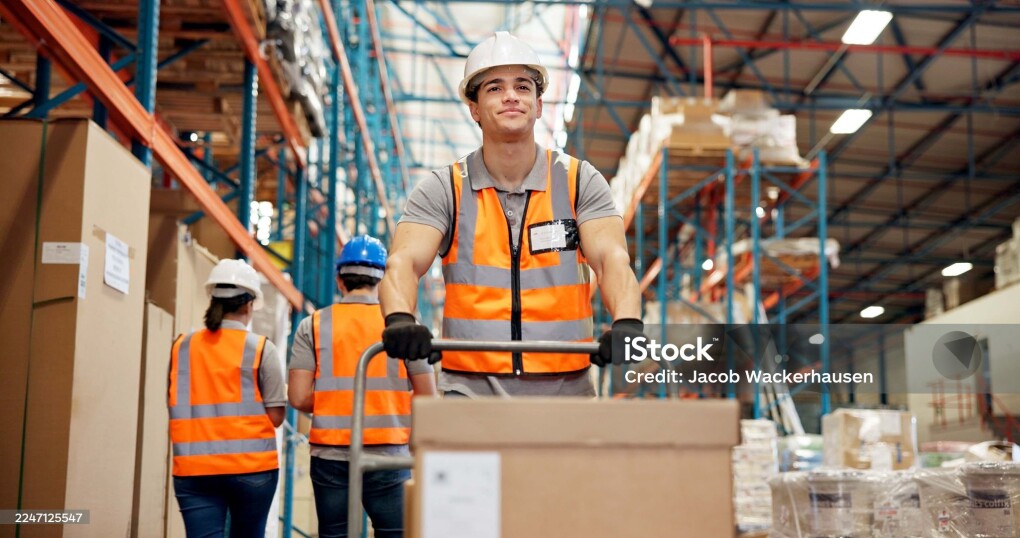 Logistics, trolley and man in warehouse with box, shipment prep or inventory management in delivery. Distribution, ppe and loader in depot with stock, dropshipping or export control in supply chain.