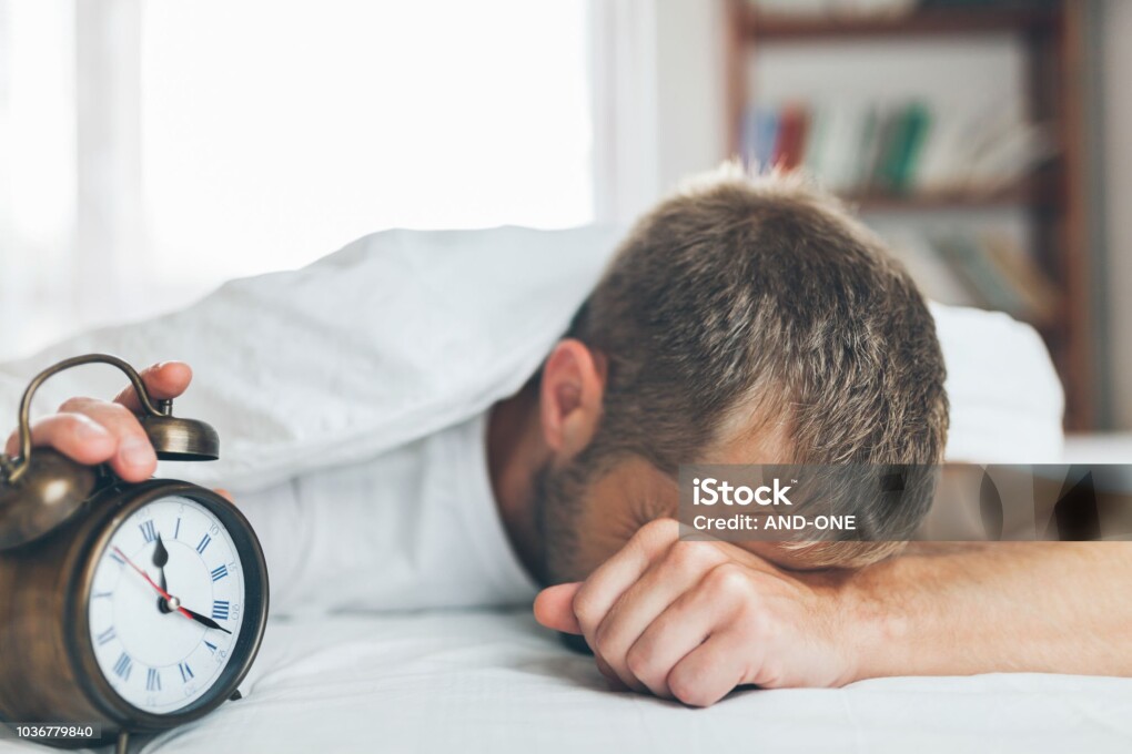 Young man finding it difficult to wake up in the morning