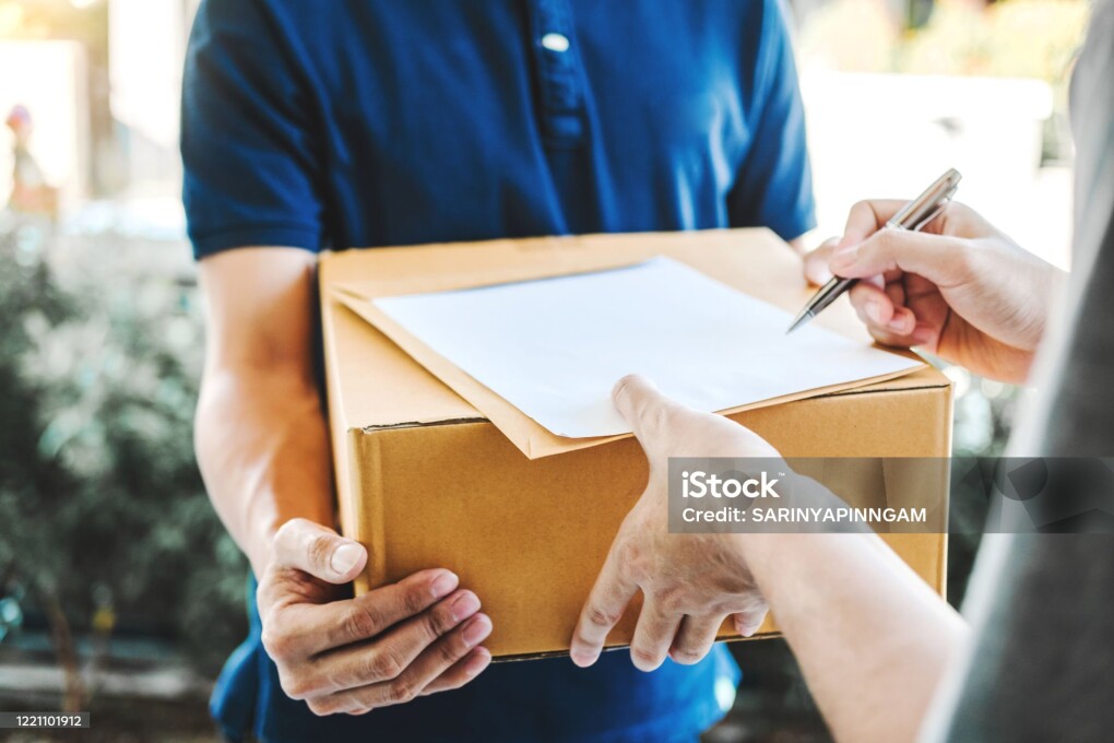 Delivery concept Asian Man hand accepting a delivery boxes from professional deliveryman at home