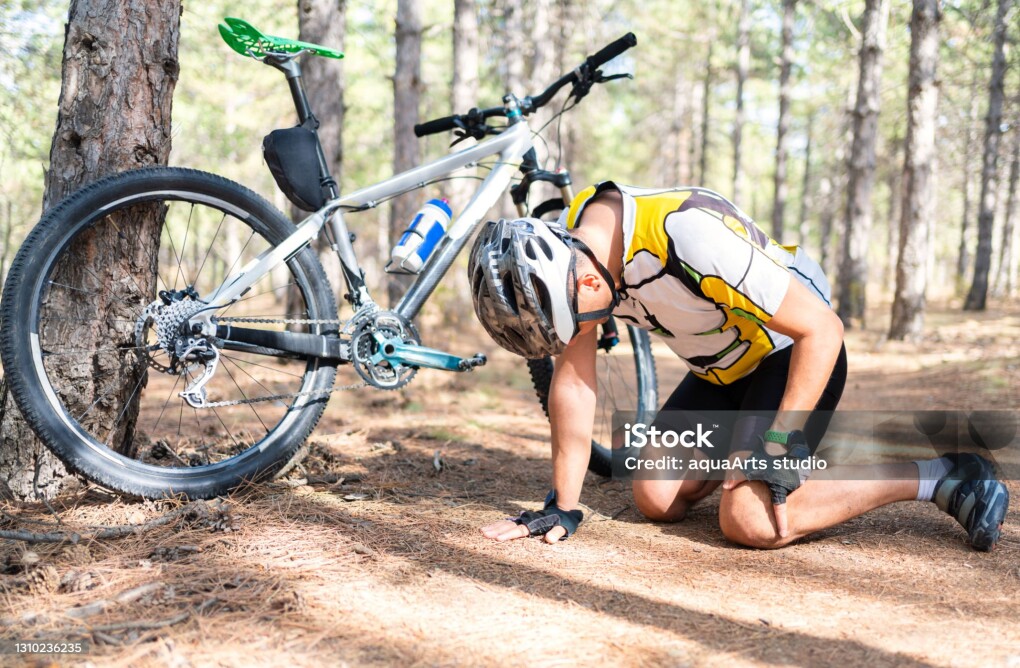 A male mountain bicycle rider injured while out on a bike ride in nature