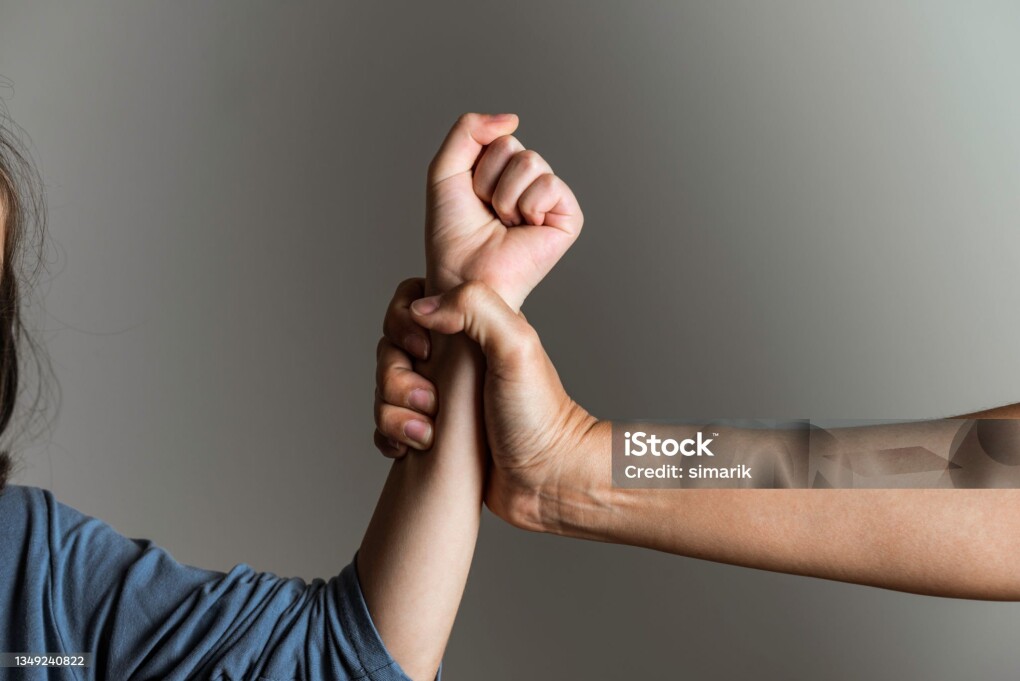 Parent is holding her little girls arm and is about to use violence. Representing child abuse and domestic violence.