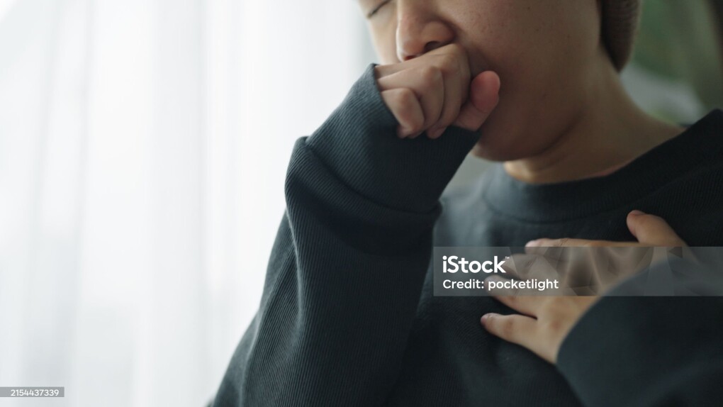 Asian teenage girl patient coughing and painful chest on wheelchair.