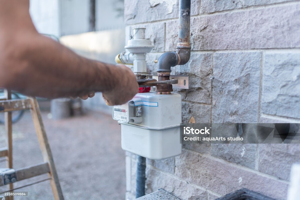 Technician Repairing Pipe And Gas Meter