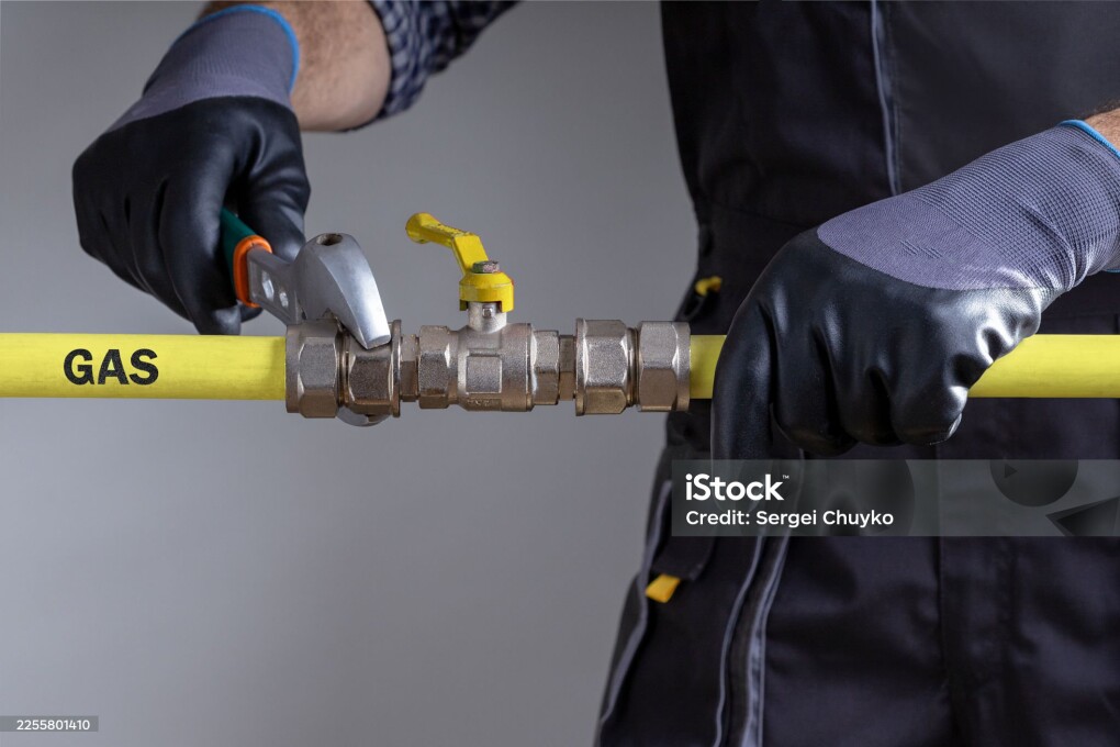 Technician repairing gas pipeline in the house.