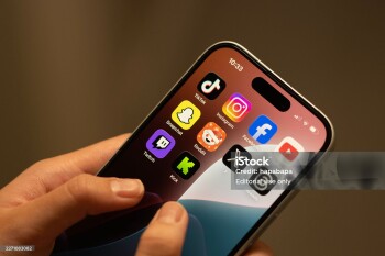 Portland, OR, USA - Dec 18, 2025: Apps (TikTok, Instagram, Facebook, YouTube, Snapchat, Reddit, X, Threads, Twitch and Kick) included in Australia's world-first teen social media ban are seen on the screen of an iPhone held by a teenager.