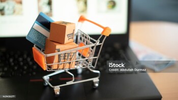 Is the payment cash or credit card? Shopping trolley and small boxes on laptop.