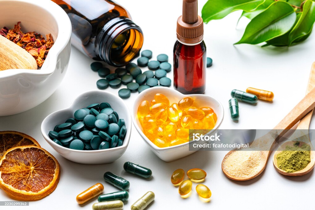 Nutritional supplements on white background. Spirulina and Omega-3 pills. Herbal therapy and essential oils. Natural vitamins or healthy eating and dieting. Healthcare or alternative medicine