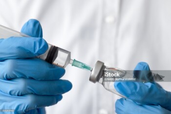Unrecognizable female medical worker preparing injection with bottle