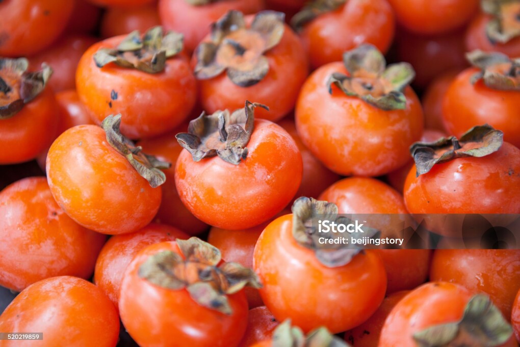 A basket full of orange persimmons.